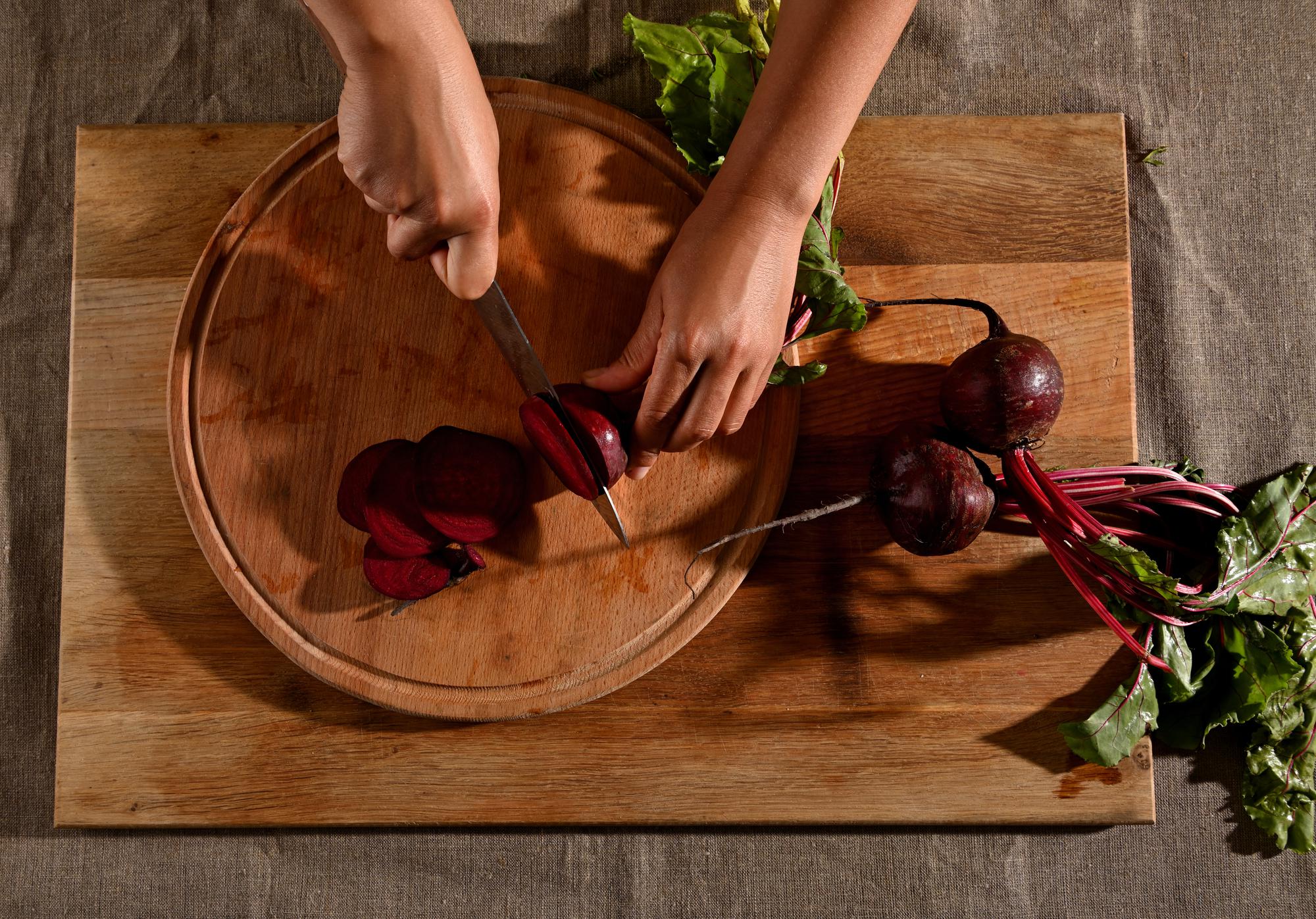 Hands prepping ingredients on wooden board
